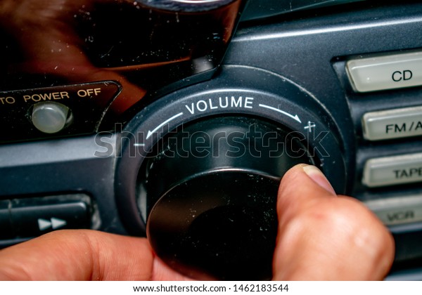 A person turning\
the volume wheel up or down (the focus is on the word \