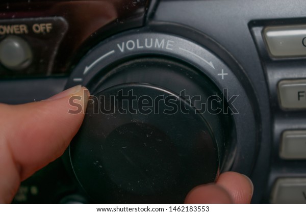 A person turning
the volume wheel up or down (the focus is on the word 