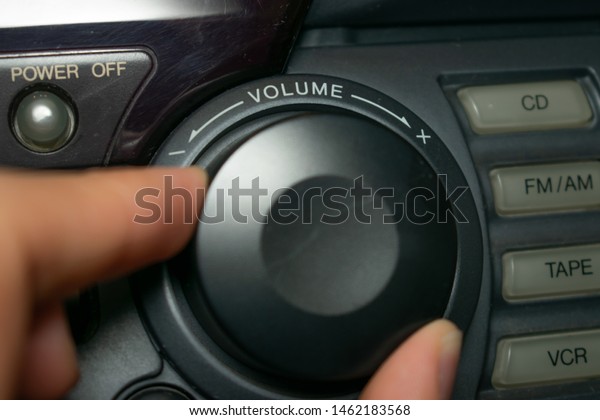 A person turning
the volume wheel up or down (the focus is on the word 
