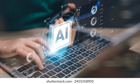 A person is typing on a laptop with a blue screen that says AI. Concept of technology and the importance of artificial intelligence in our daily lives - Powered by Shutterstock