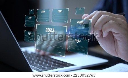 person typing on a laptop computer with new year 2023 business plan in document file.