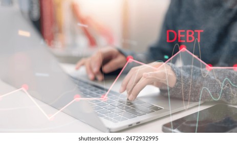 A person is typing on a laptop with the word debt written on the screen. Concept of financial stress and responsibility - Powered by Shutterstock