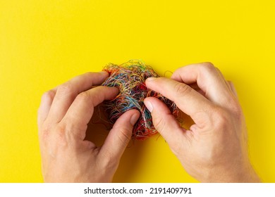 A Person Untangle A Ball Of Threads With His Hands. The Concept Of Solving Complex Problems. Crime Investigation Concept. Concept Of Psychological State.