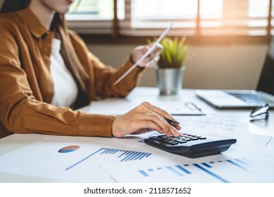 person using calculator calculating tax refund on the table - Shutterstock ID 2118571652