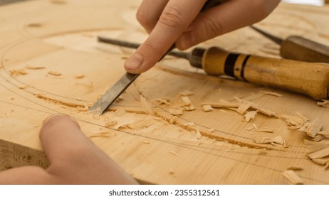 person using chisel while curving wood