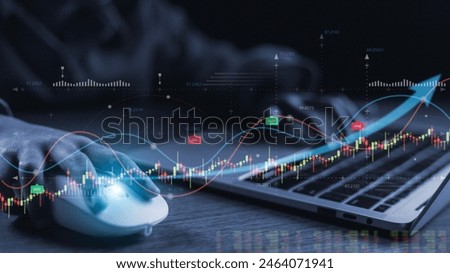 A person is using a computer mouse to navigate a graph on a laptop. The graph is filled with various lines and numbers, and the person appears to be focused on the data