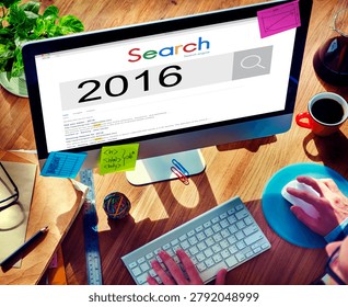 A person using a computer with a search engine displaying '2016'. The desk is cluttered with papers, sticky notes, and office supplies.