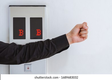 Person using elbow the press elevator instead using hand and fingers for corona virus or covid-19 prevention, hygiene to stop spreading the virus.