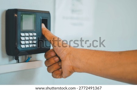 A person is using a fingerprint reader to access a building