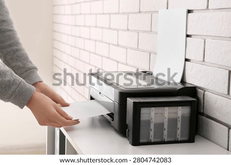 Person using inkjet printer to print paper