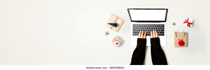 Person using a laptop computer with Christmas gift boxes from above - Powered by Shutterstock