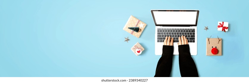 Person using a laptop computer with Christmas gift boxes from above
