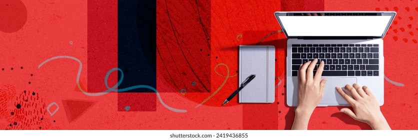 Person using a laptop computer with a notebook - Flat lay