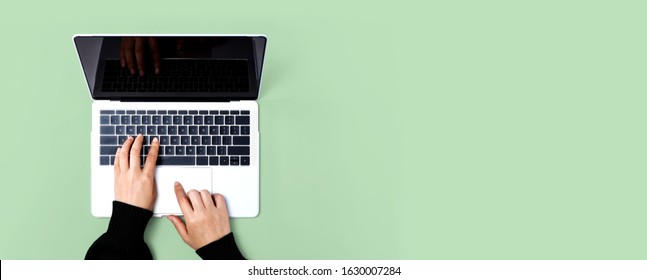 Person Using A Laptop Computer On A Solid Color Background