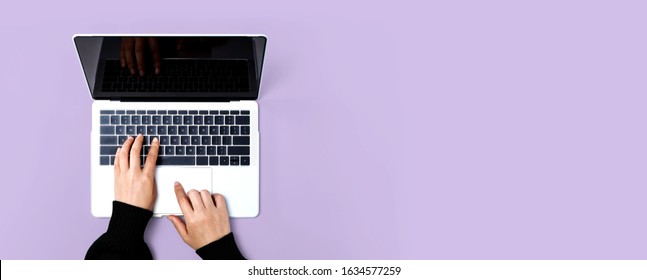 Person Using A Laptop Computer On A Solid Color Background