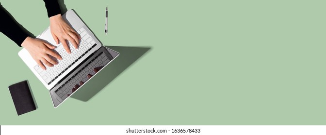 Person Using A Laptop Computer On A Solid Color Background