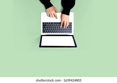 Person Using A Laptop Computer On A Solid Color Background