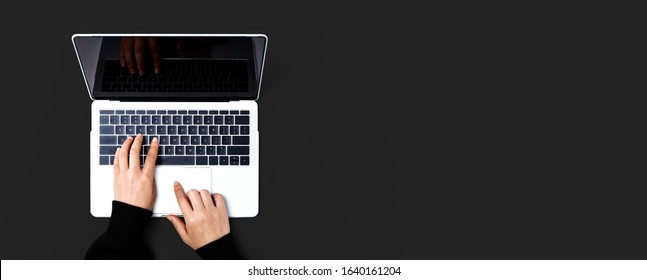 Person Using A Laptop Computer On A Solid Color Background