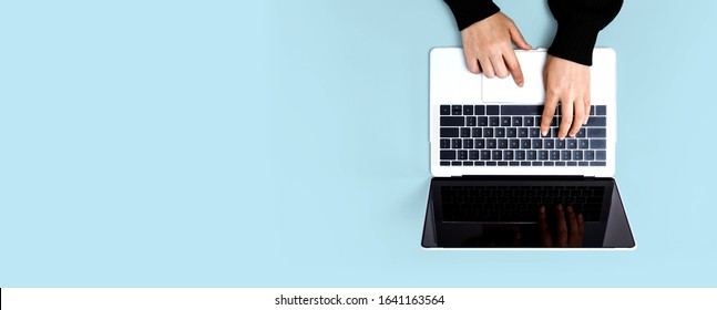 Person Using A Laptop Computer On A Solid Color Background