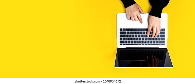 Person Using A Laptop Computer On A Solid Color Background