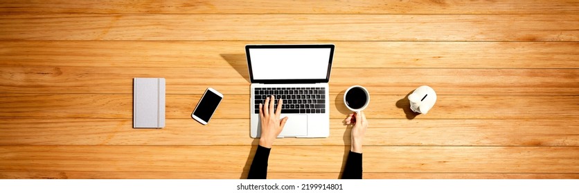 Person Using A Laptop Computer With A Piggy Bank - Flat Lay