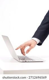 Person using a laptop at a desk while dressed in formal business attire in a bright indoor setting during daylight hours
