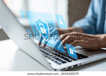 Person using laptop with digital security shield and lock icons displayed on screen.