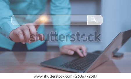 A person using a laptop while interacting with a transparent virtual search bar. Represents internet browsing, search engine usage, digital marketing, data access, or user interface innovation.