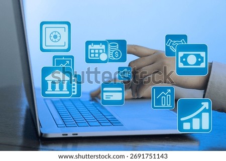 A person is using a laptop while interacting with various financial icons like charts and currency symbols. The background is softly lit, emphasizing the digital workspace.