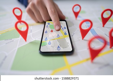 Person Using Map With Red Location Markers On Mobile Phone