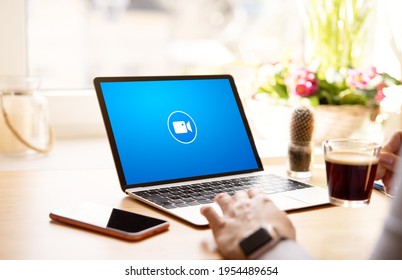 Person using online video meeting program on laptop computer