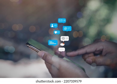 Person using a social media marketing concept on mobile phone with notification icons of like, message, comment and star above smartphone screen. - Powered by Shutterstock