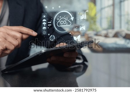 A person using a tablet to interact with digital icons related to carbon dioxide, showcasing themes of environmental awareness, pollution, and sustainability.