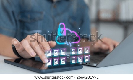 Person using tablet and laptop with secure cloud storage icon and photo file transfer concept, digital data protection, and online backup technology.