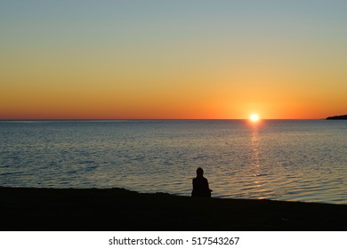 Person viewing a sunset over the ocean.