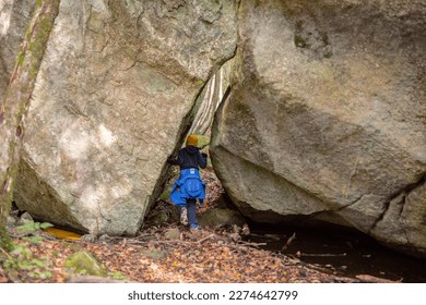 A person walking between two large boulders.