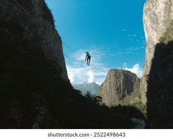 A person is walking on a slackline stretched between two towering cliffs in a deep canyon. - Powered by Shutterstock