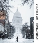 Person Walks On State Street During Snowstorm in Madison Wisconsin with Capitol in Background