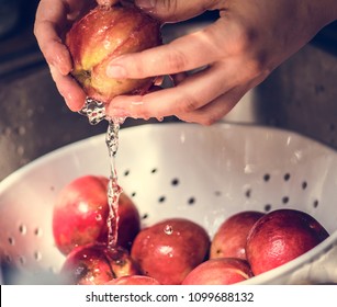 A person washing pomegranate under running water food photography idea
