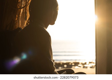 Person watching golden sunset over ocean beach from a camper van in South Australia
