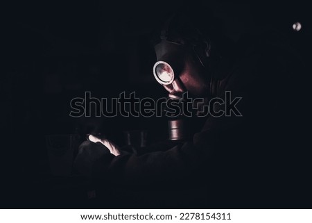 person wearing a gas mask watching something