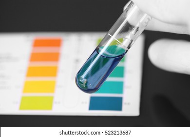 Person Wearing Gloves Testing The PH Of A Chemical In A Test Tube