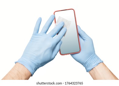 A Person Wearing Protective Medical Gloves Wipes His Mobile Phone With A Disinfectant, As One Of The Main Carriers Of Bacteria And Viruses. The Concept Of The Coronavirus Kovid-19 And OCD