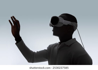 A person wears a AR headset, immersed in virtual reality. The sleek design suggests advanced technology, used for gaming, virtual meetings, education, or immersive entertainment in futuristic - Powered by Shutterstock