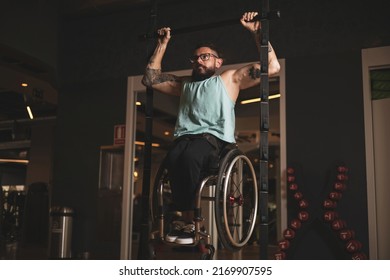A person in a wheelchair inside a gym doing pull-ups to work his lats. - Powered by Shutterstock