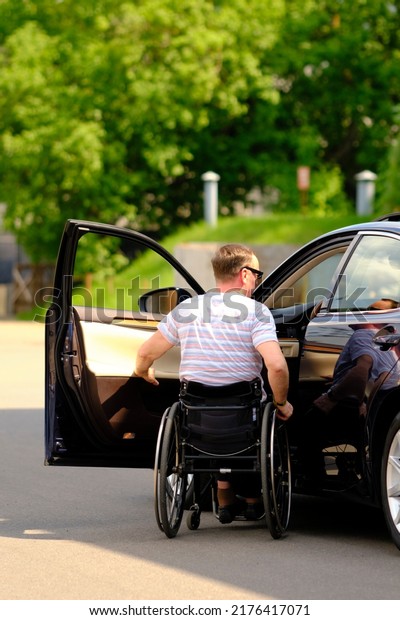 a person in a wheelchair trains to sit in the\
driver\'s seat in a car