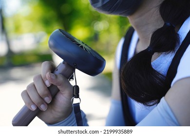 Person Who Cools Off With A Handy Fan