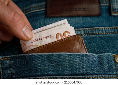 The Person Who Wants To Take The Wallet Full Of Money In His Jeans Pocket