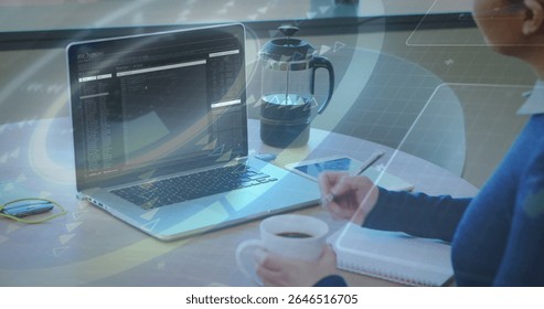 Person working on laptop with data processing image over coffee and notepad. Technology, remote work, digital, business, office, multitasking