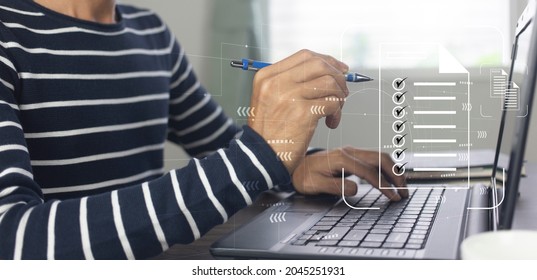 person working on laptop and management with document check list at work place,business office process system concept